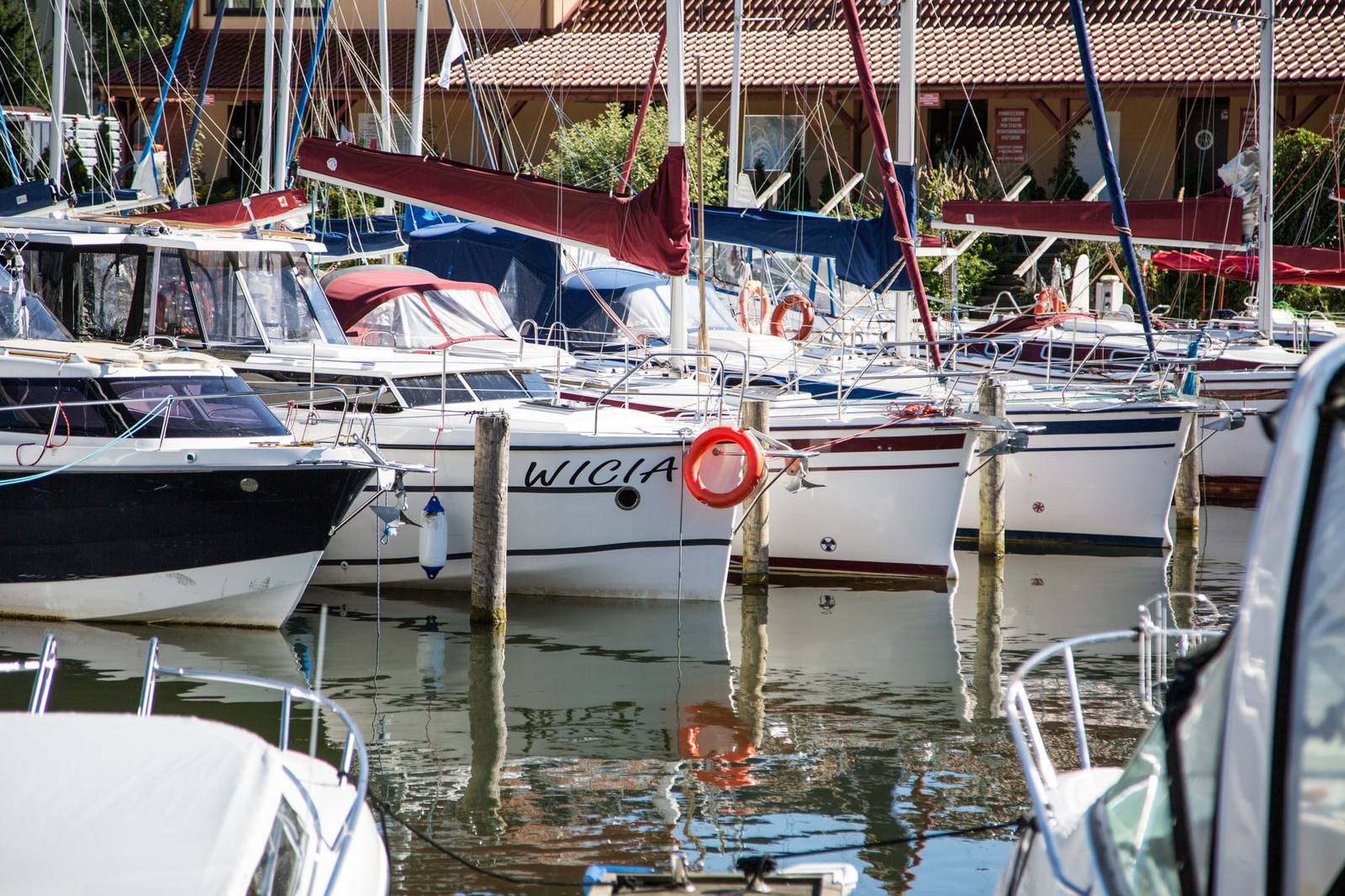 Zabudowania Mariny Port Royal z czerwonymi dachami za zacumowanymi jachtami